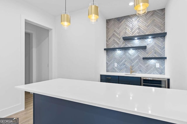 kitchen featuring wine cooler, light hardwood / wood-style flooring, sink, and pendant lighting