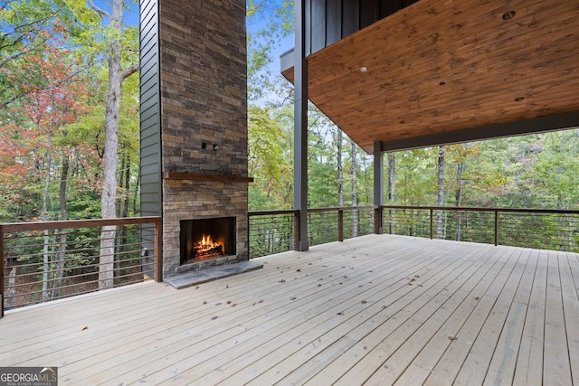 deck with an outdoor stone fireplace