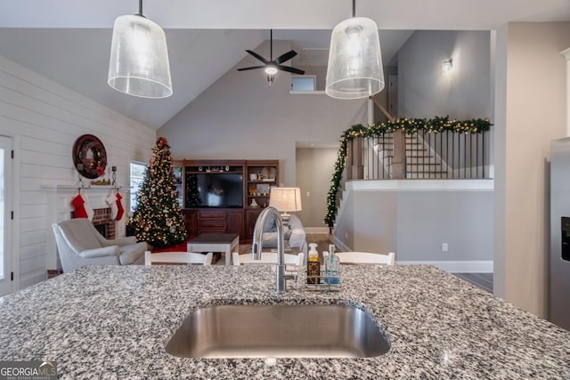 kitchen with sink, decorative light fixtures, and light stone countertops