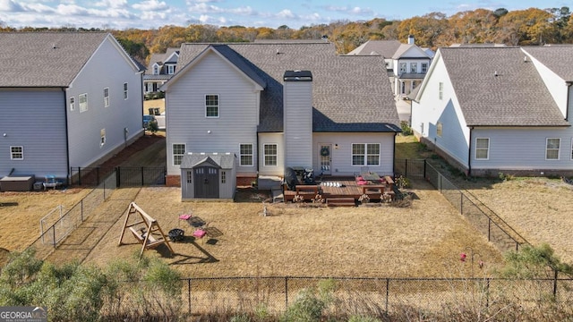 rear view of property with a shed and a wooden deck