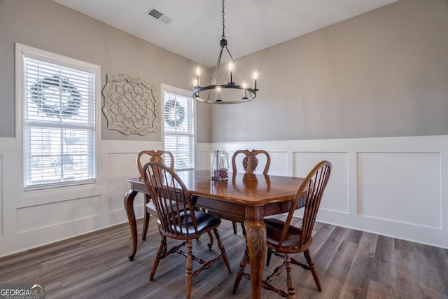 dining space with dark wood-type flooring and a chandelier