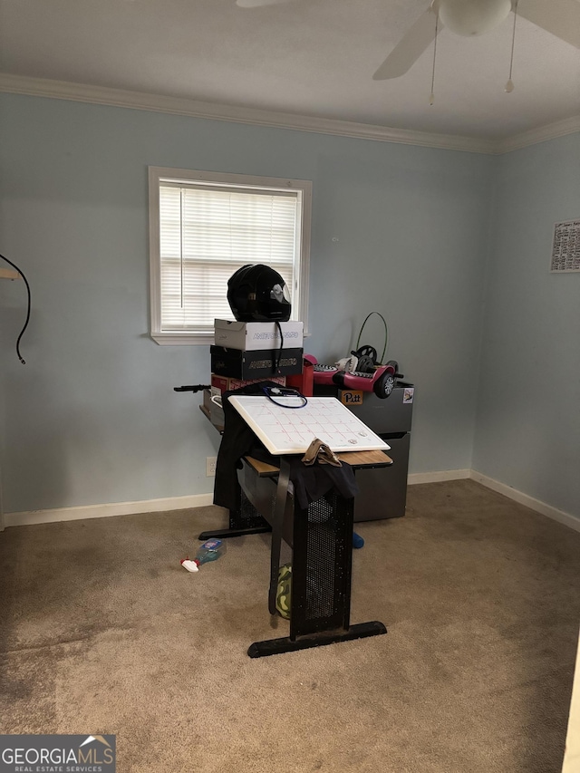 carpeted home office featuring baseboards, ornamental molding, and ceiling fan