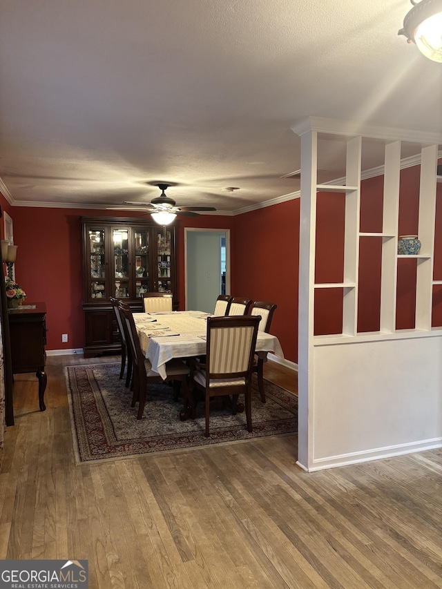 dining room featuring a ceiling fan, baseboards, ornamental molding, and wood finished floors