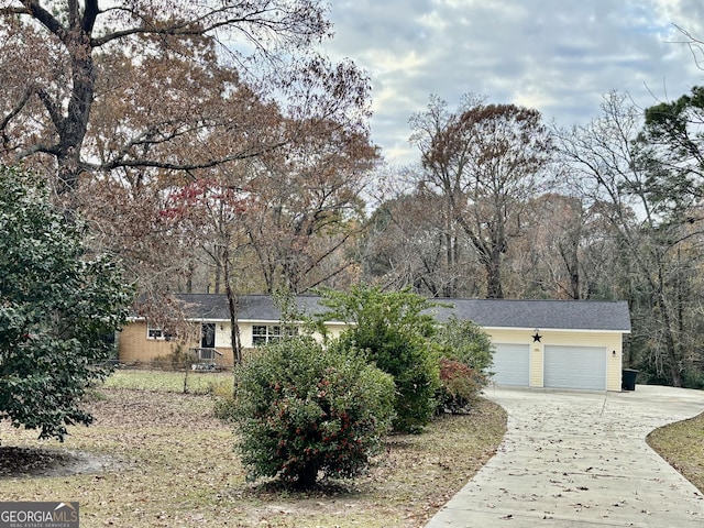 single story home featuring concrete driveway and an attached garage