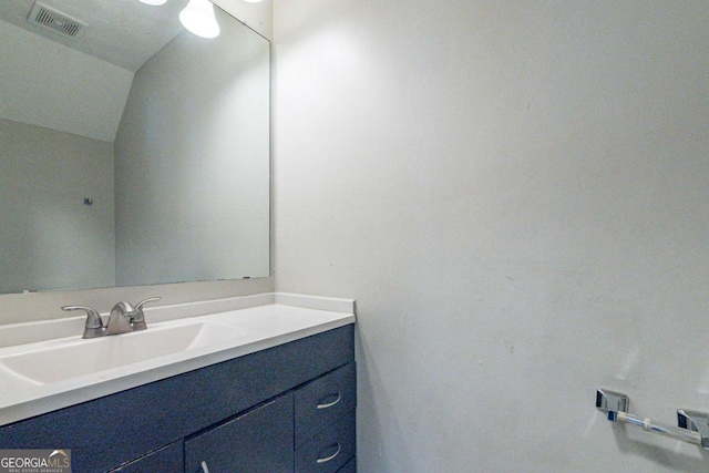 bathroom with vanity and lofted ceiling