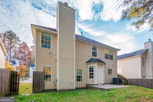 rear view of house with a patio and a lawn