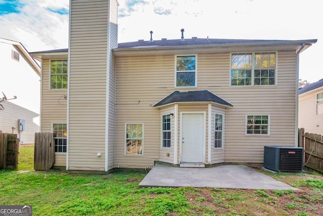 rear view of house with a yard, cooling unit, and a patio area