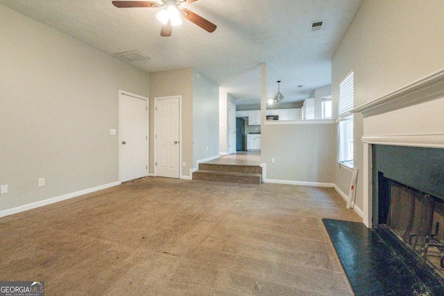 unfurnished living room with ceiling fan and carpet floors