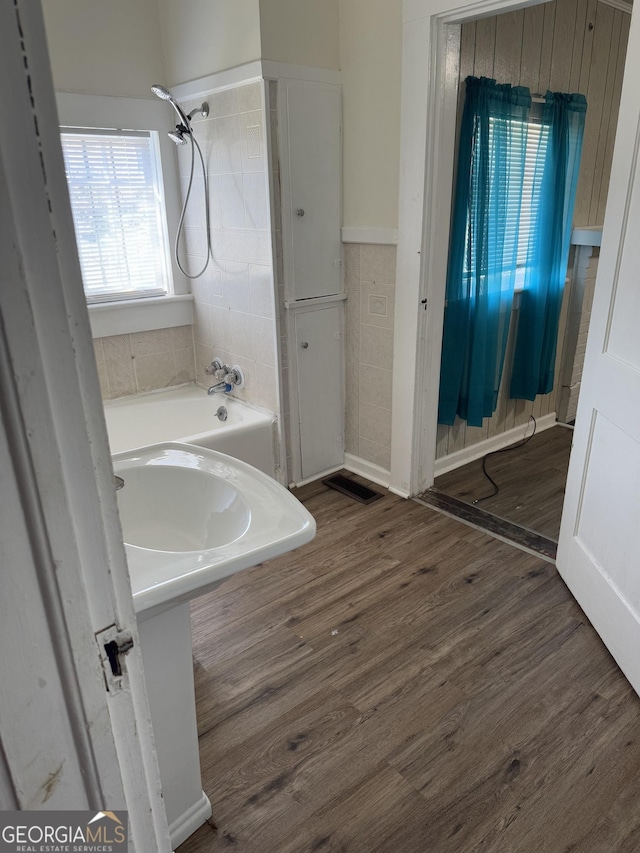 bathroom with a bath and wood-type flooring