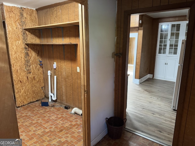 laundry room with wood walls and wood-type flooring