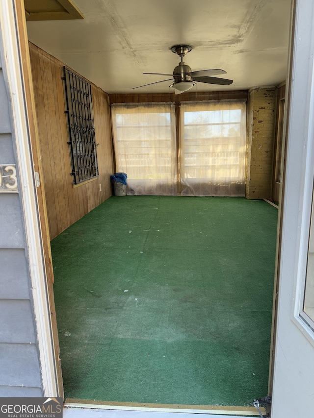 unfurnished sunroom featuring ceiling fan