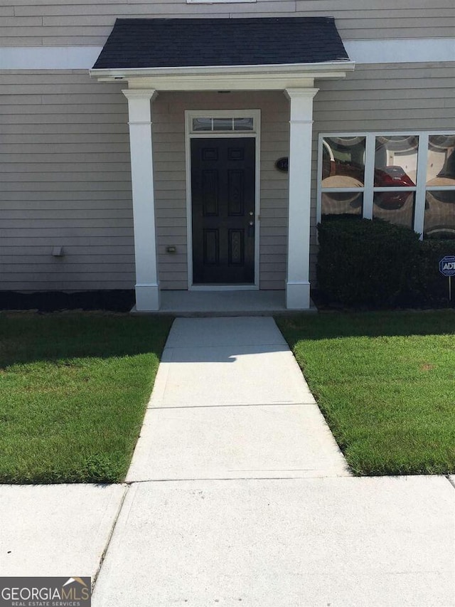 view of exterior entry with a lawn