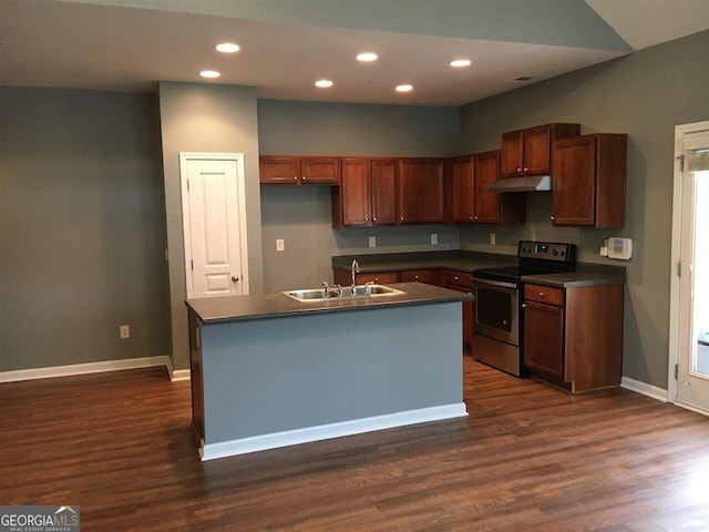 kitchen with sink, dark wood-type flooring, stainless steel range with electric cooktop, and an island with sink