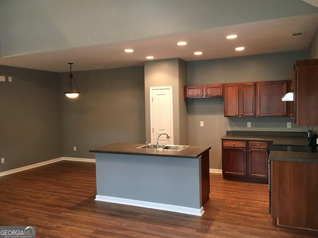 kitchen featuring a kitchen island with sink, sink, pendant lighting, and dark hardwood / wood-style floors