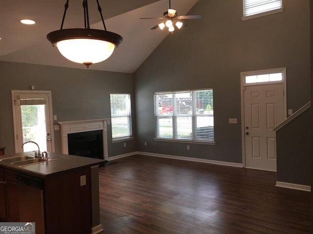 unfurnished living room featuring dark hardwood / wood-style flooring, high vaulted ceiling, ceiling fan, and sink