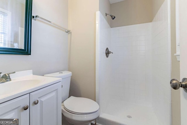 bathroom featuring vanity, toilet, and tiled shower