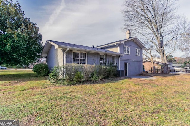 split level home with central AC unit and a front yard