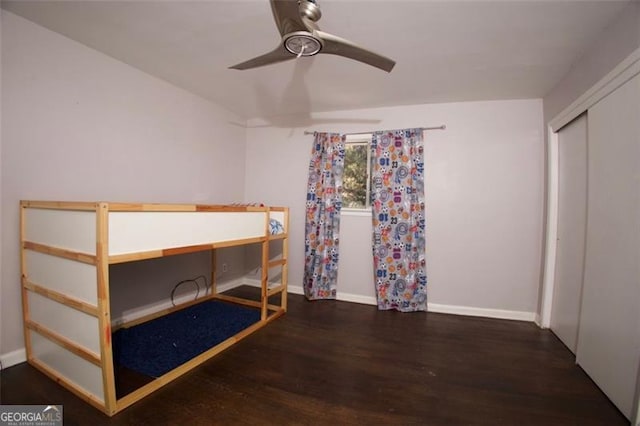 unfurnished bedroom featuring ceiling fan, a closet, and dark hardwood / wood-style floors