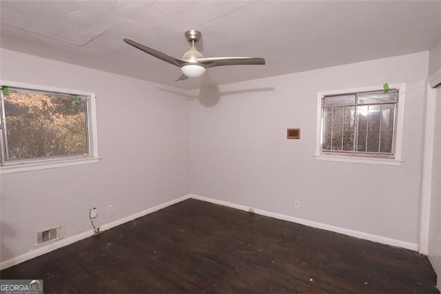 unfurnished room with ceiling fan and dark wood-type flooring