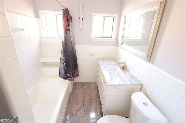 bathroom featuring vanity, toilet, and tile walls