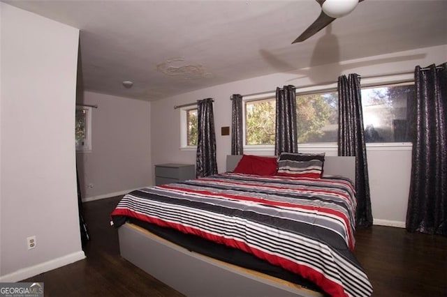 bedroom with dark hardwood / wood-style floors, multiple windows, and ceiling fan