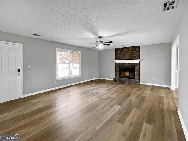 165 Riverbend Dr, Covington, GA 30014 - unfurnished living room with hardwood / wood-style floors, ceiling fan, a fireplace, and a textured ceiling