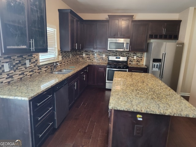 kitchen featuring light stone counters, dark hardwood / wood-style flooring, sink, and stainless steel appliances