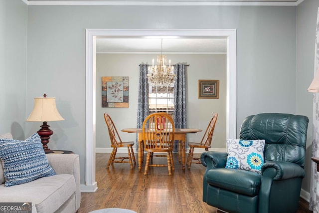 dining space with a chandelier, crown molding, and wood-type flooring