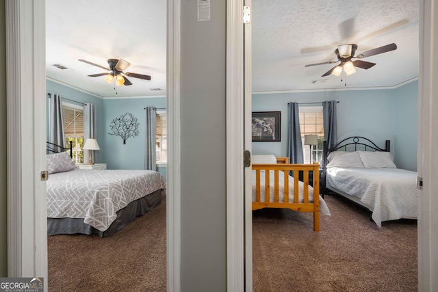 bedroom with ceiling fan, carpet floors, a textured ceiling, and ornamental molding