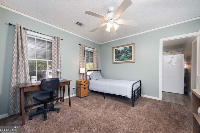 carpeted bedroom with multiple windows, a textured ceiling, ceiling fan, and ornamental molding