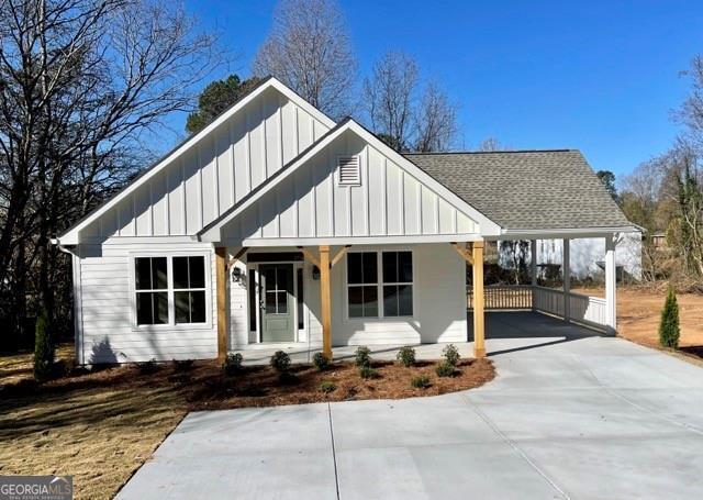 modern farmhouse style home featuring a porch and a carport