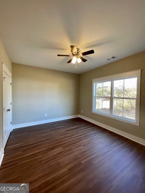 spare room with dark hardwood / wood-style floors and ceiling fan