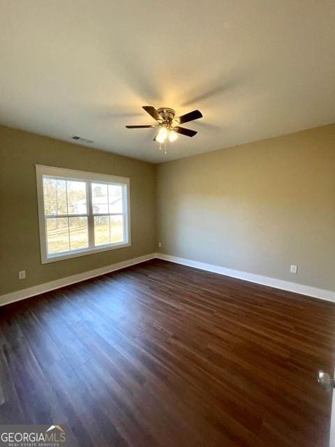 spare room with ceiling fan and dark hardwood / wood-style flooring