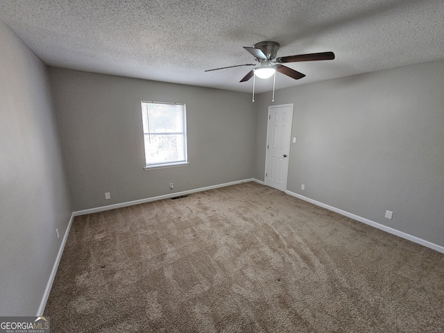 carpeted empty room featuring ceiling fan, visible vents, baseboards, and a textured ceiling