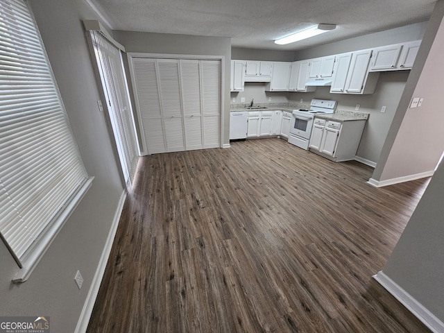 kitchen with white cabinets, dark hardwood / wood-style floors, white appliances, and sink