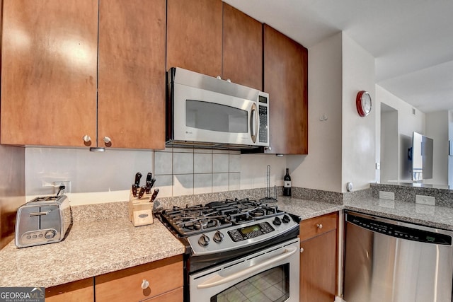 kitchen with light stone countertops and stainless steel appliances