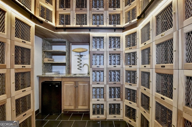 wine area with dark tile patterned flooring and sink