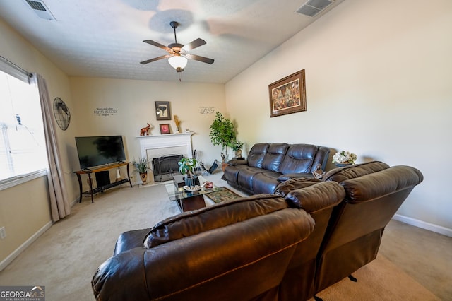 carpeted living room with a textured ceiling, ceiling fan, and a healthy amount of sunlight