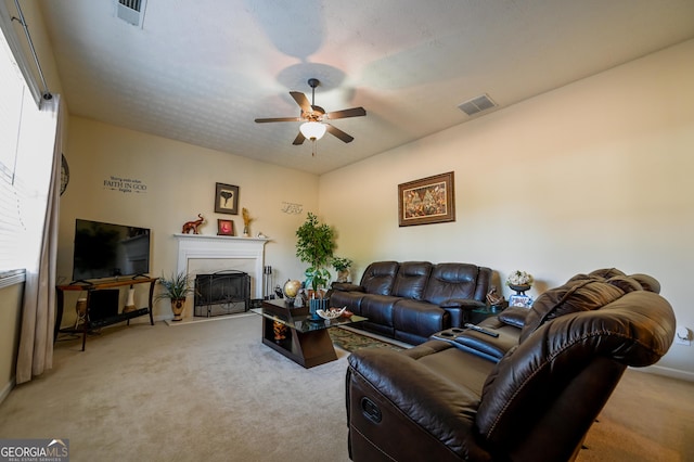 living room featuring ceiling fan, light colored carpet, and a healthy amount of sunlight