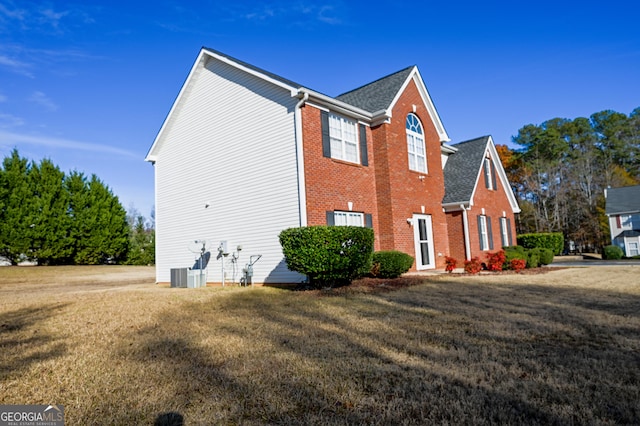 view of side of home with cooling unit and a yard