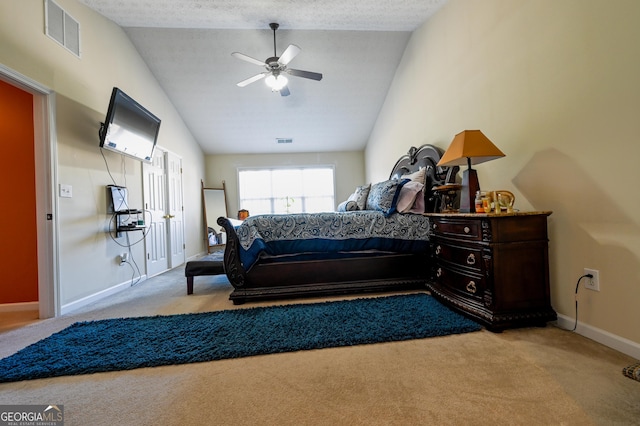 carpeted bedroom with a textured ceiling, vaulted ceiling, and ceiling fan