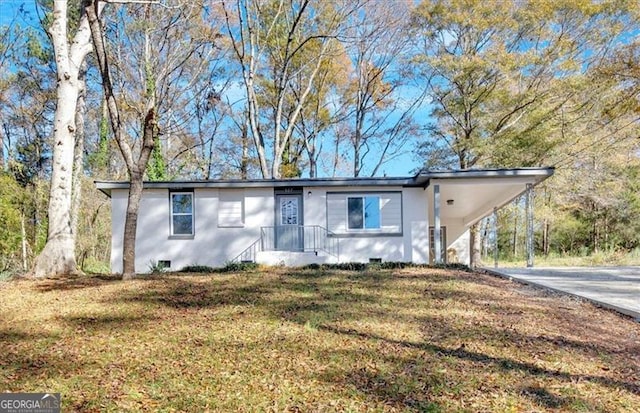 ranch-style home featuring a front yard and a carport