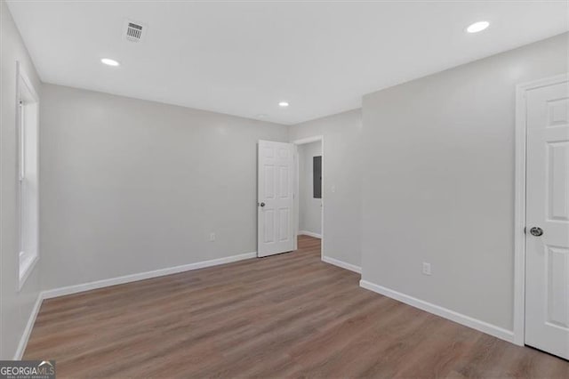 empty room featuring electric panel and hardwood / wood-style floors