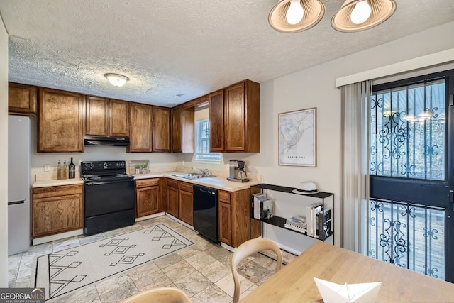 kitchen with black appliances, sink, and a textured ceiling