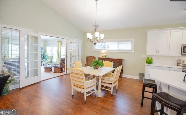 dining space with vaulted ceiling, dark hardwood / wood-style floors, and a notable chandelier