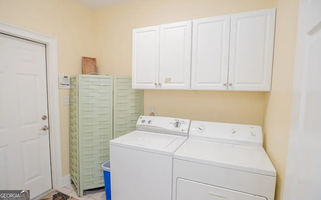 laundry area featuring washer and clothes dryer, cabinets, and light tile patterned floors