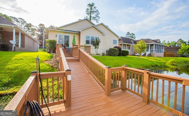 rear view of property with a yard, a wooden deck, and a sunroom