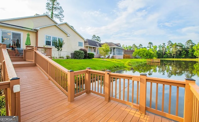 wooden deck featuring a lawn, a sunroom, and a water view