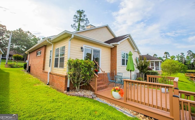 rear view of property with a lawn and a deck