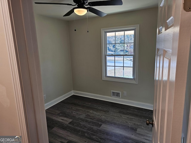 empty room featuring ceiling fan and dark wood-type flooring